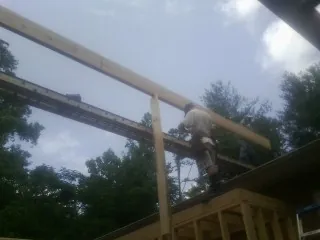 Carpenter setting a ridge beam over a new addition frame — Ice Dam Removal by Roofing Brothers in Fiatt