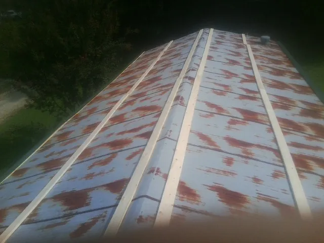 Rusted metal roof panels with new wood purlins before replacement — Storm Damage Roof Repair in Fiatt by Roofing Brothers