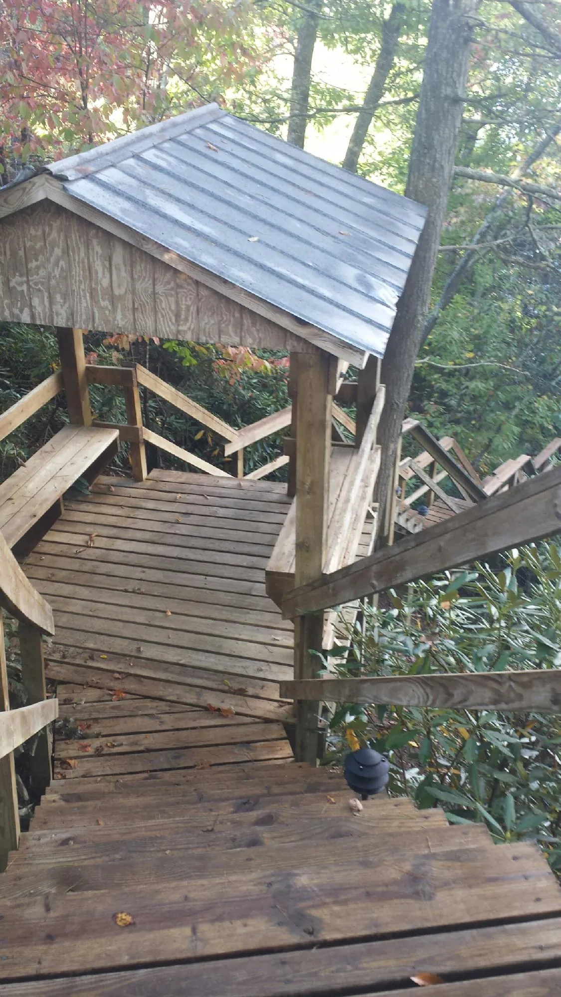 Metal roofed shelter over wooden steps on a wooded walkway — Skylight Repair & Installation work by our crew in Fiatt